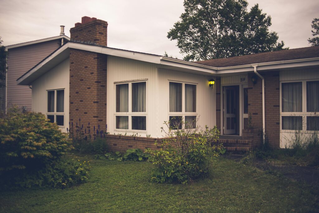 Cozy brick house nestled in lush greenery during twilight, showcasing serene residential architecture.